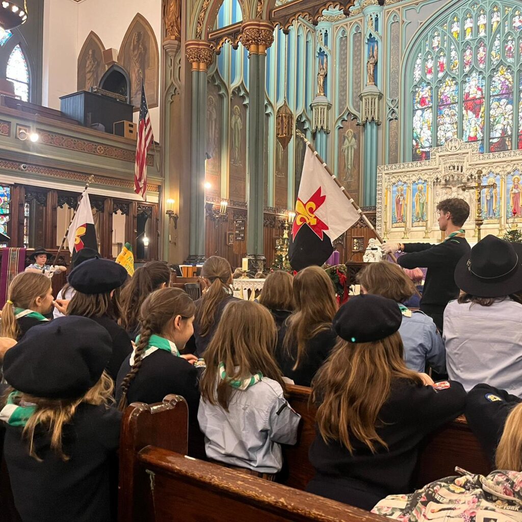 Éclaireuse et éclaireurs présentant le baussant devant le chœur de l'église